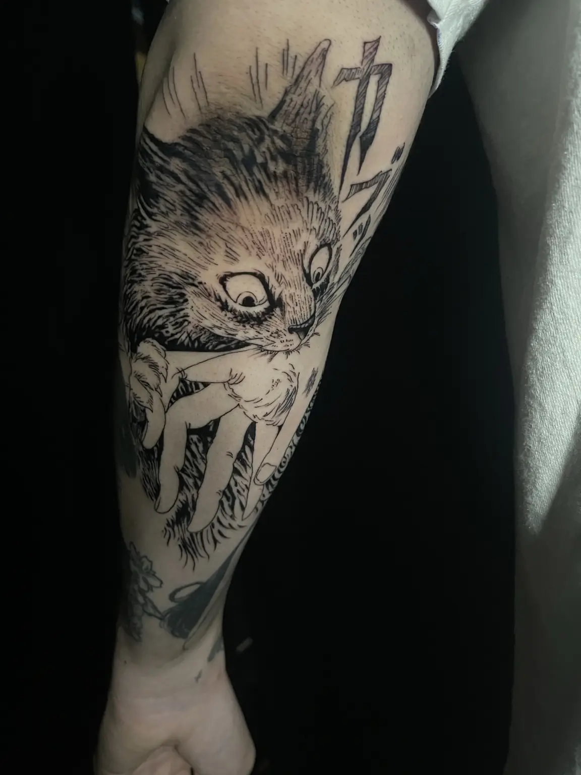Black-and-gray manga tattoo of a cat biting a hand by Keith at Neo Tokyo Tattoos